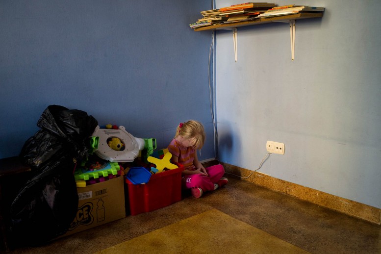 Nicolette se sienta en la esquina de una habitación en un orfanato donde vive con sus cuatro hermanos en Varsovia, Polonia. Autor: Maciek Nabrdalik