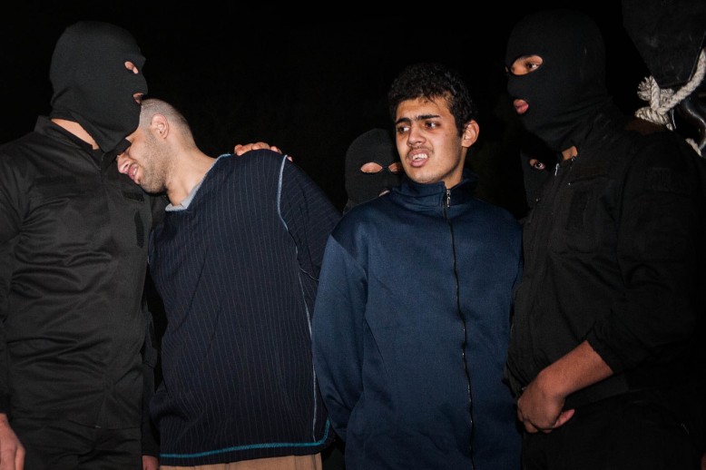 Alireza Mafiha (23) pone su cabeza en el hombro de un verdugo el 20 de enero, minutos antes de que él y Mohammad Ali Sarvari (20) fueran ahorcados en Irán. Autor: Amir Pourmand