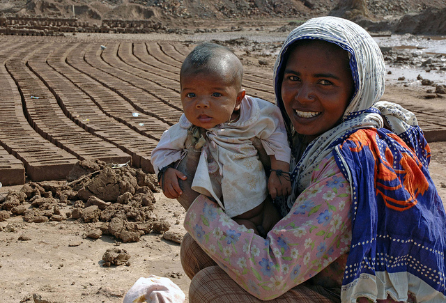 Brickyard worker with her young child. M.Crozet/ILO vía Flickr.