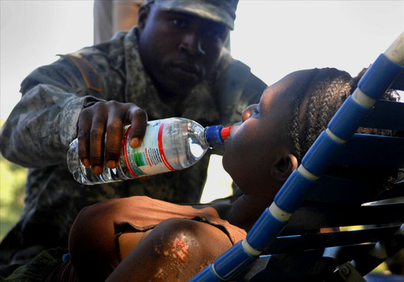 Soldado norteamericano ayudando a una haitiana damnificada. [Fuente: Fotopedia.com]