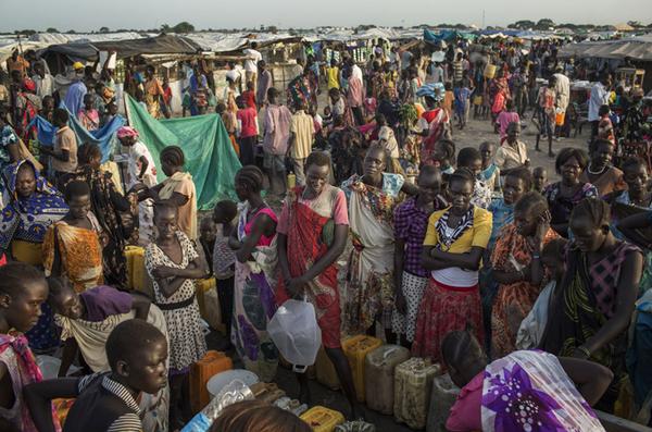 Personas esperando a llenar bidones de agua en un campo de desplazados. Fuente: Africa News and Analysis