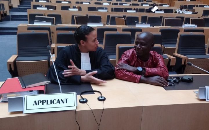 [Foto: Burkinabe journalist Lohé Issa Konaté (R) discusses strategy with one his attorney, MLDI Legal Director Nani Jansen. Photo courtesy MLDI]