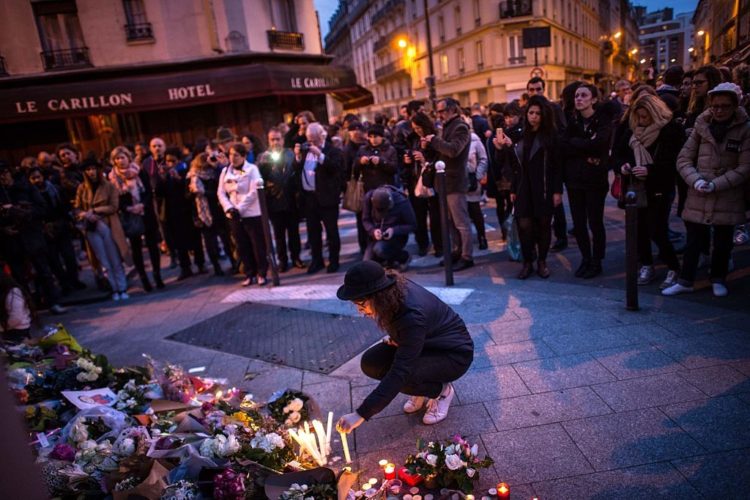 Una persona deposita flores ante el restaurante The Petit Cambodge, uno de los lugares que sufrió ataques terroristas en París.